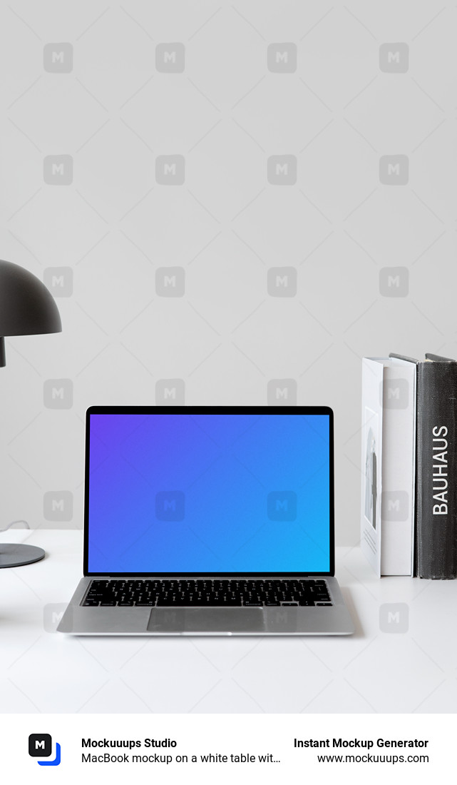 MacBook mockup on a white table with books stacked vertically at the side
