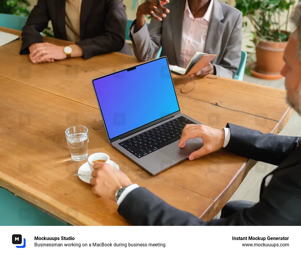 Businessman working on a MacBook during business meeting