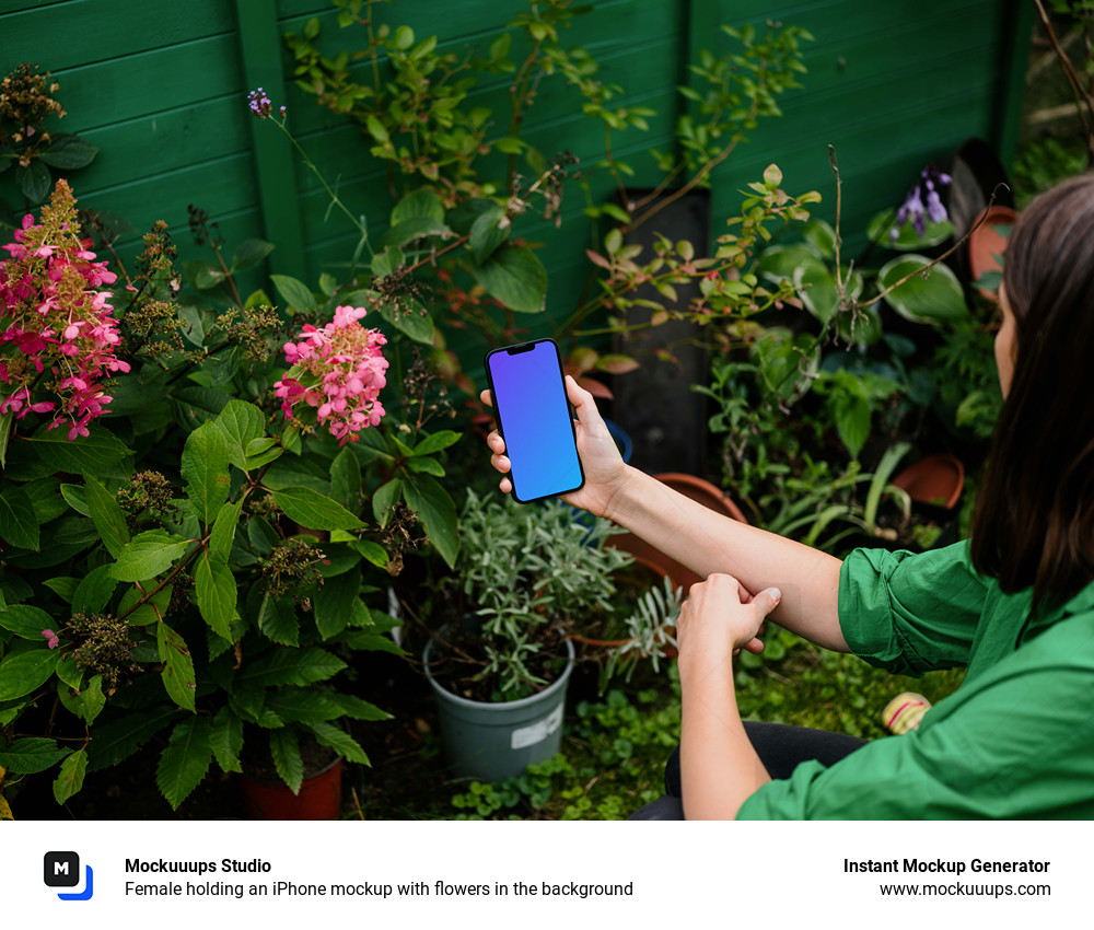 Female holding an iPhone mockup with flowers in the background