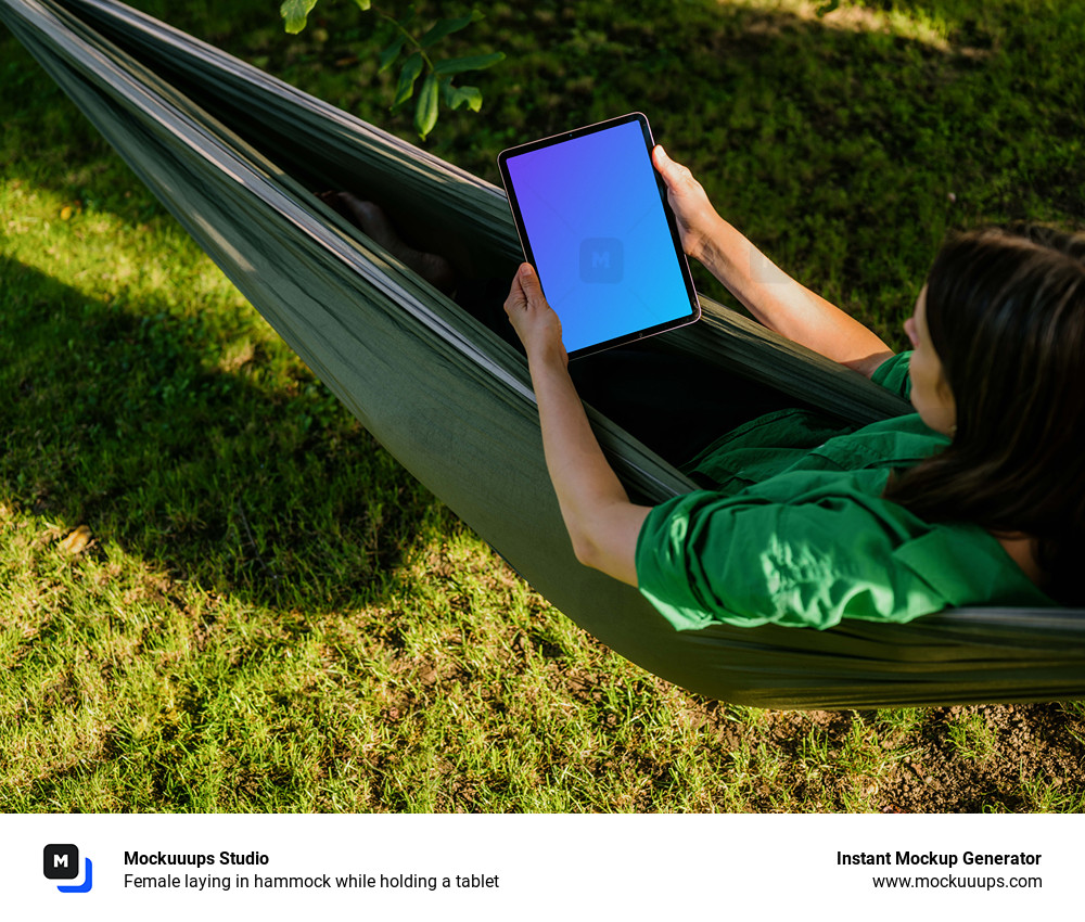 Female laying in hammock while holding a tablet