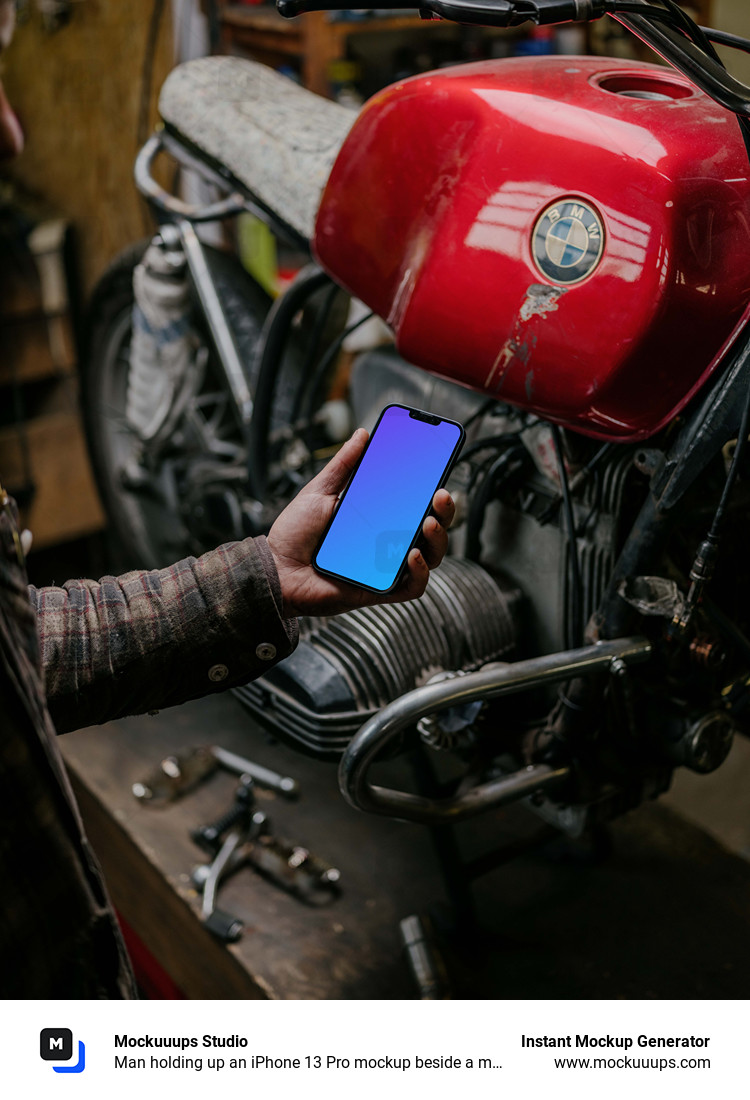 Man holding up an iPhone 13 Pro mockup beside a motorcycle