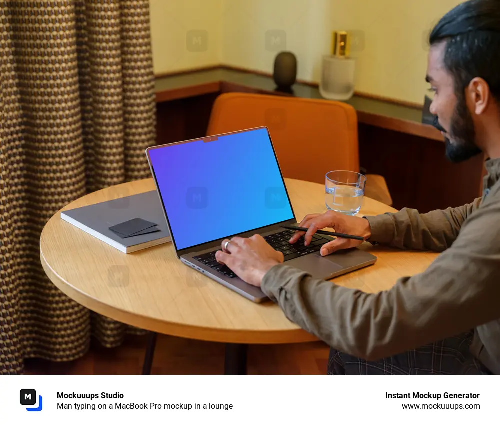 Man typing on a MacBook Pro mockup in a lounge