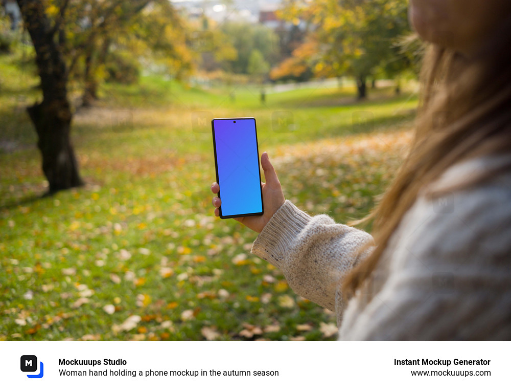 Woman hand holding a phone mockup in the autumn season