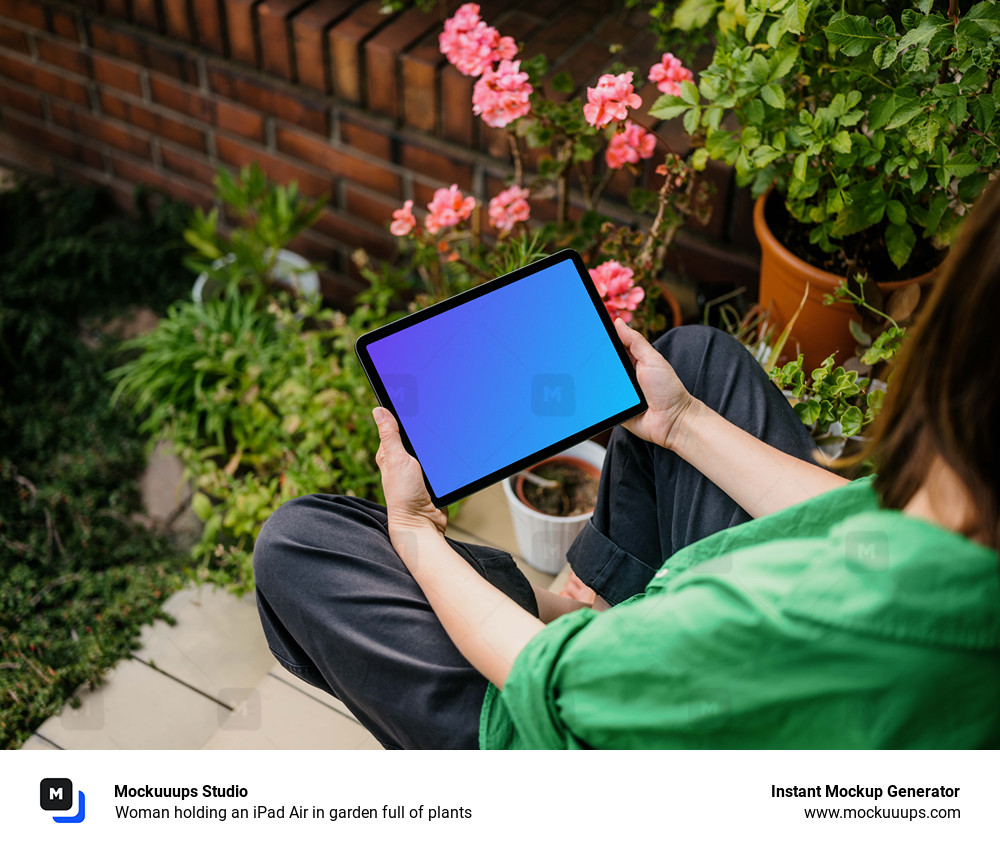 Woman holding an iPad Air in garden full of plants