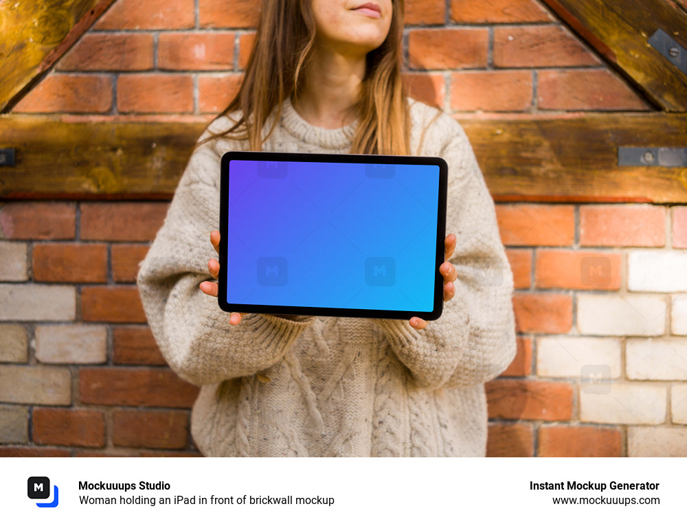 Woman holding an iPad in front of brickwall mockup