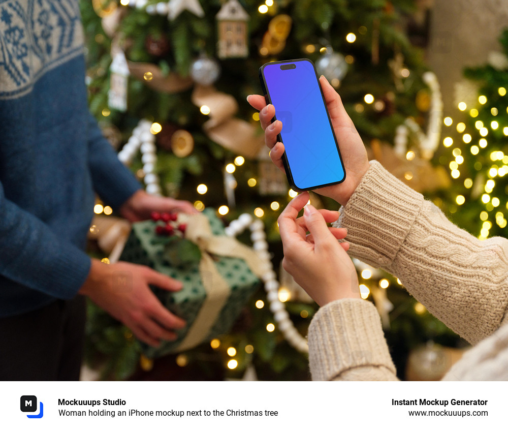 Woman holding an iPhone mockup next to the Christmas tree