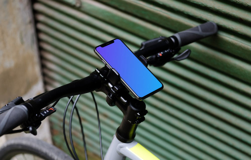 Bike leaned against a garage with iPhone 11 Pro mockup in bike mount