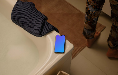 iPhone 13 mockup on an edge of a bathtub