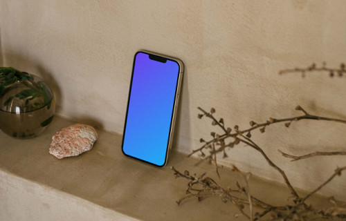 iPhone 13 Pro mockup next to a teapot and plant