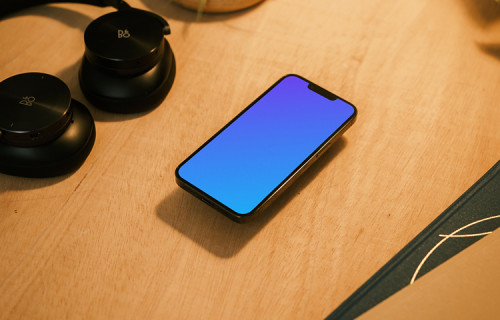iPhone 13 Pro mockup with a pair of headphones at the side