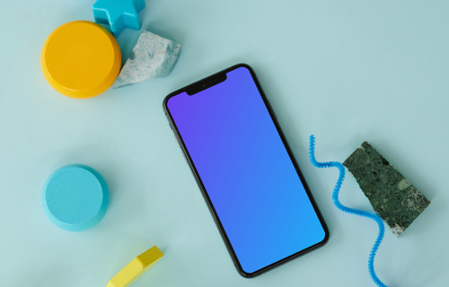 iPhone mockup on a blue table beside a pair of ebuds