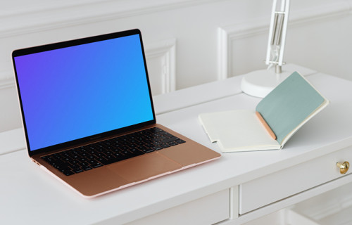 MacBook Air mockup on a table beside an open notepad  