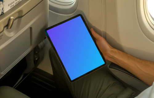 Man using iPad Air mockup while sitting in airplane