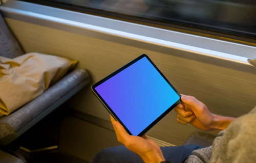 Passenger holding tablet mockup on the train