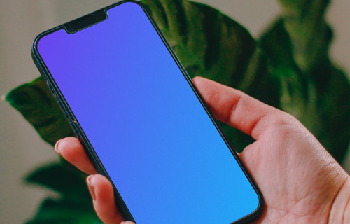 Person holding an iPhone 13 mockup