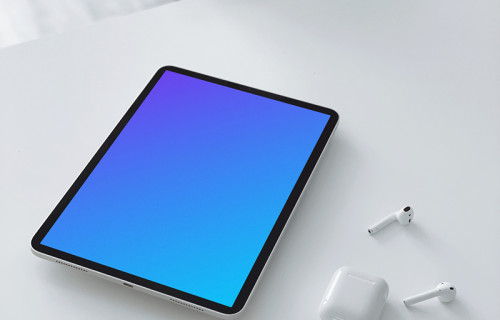 Tablet mockup on a table with a pair of Airpods 2 