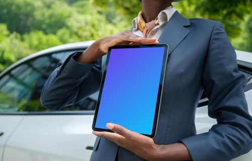 Businesswoman with iPad Mockups standing next to the Tesla