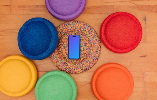 Colorful foam circles and smartphone mockup on wooden floor