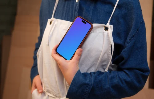 Crafter holding an iPhone mockup in the workshop