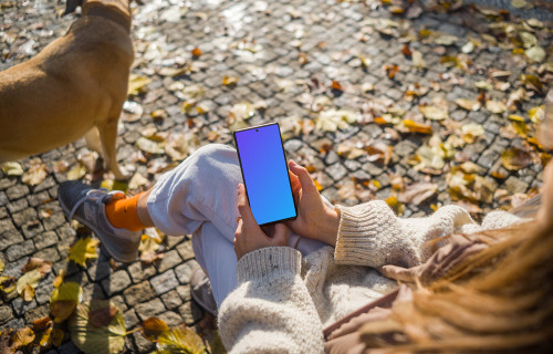 Manos femeninas sosteniendo un Google Pixel 6 en tema otoñal mockup