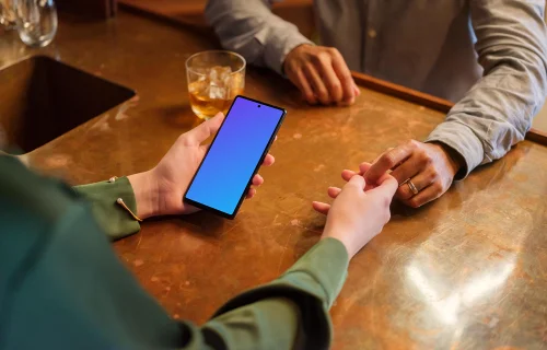 Female holding a Google Pixel 6 mockup in the lounge