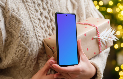 Mujer sosteniendo un Google Pixel y un regalo de Navidad mockup