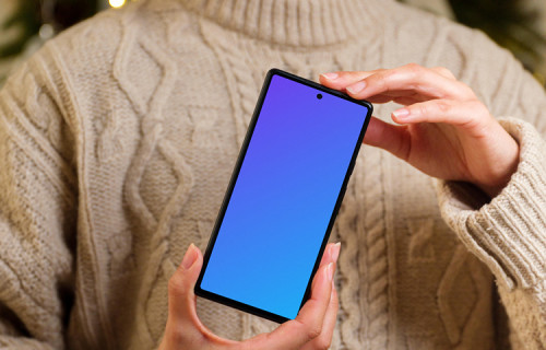 Mujer sosteniendo un teléfono mockup en tema navideño