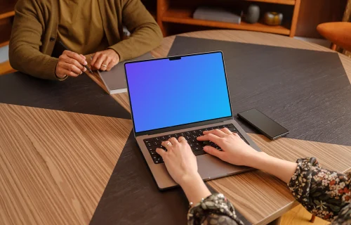 Mujer escribiendo en un MacBook Pro mockup en la oficina