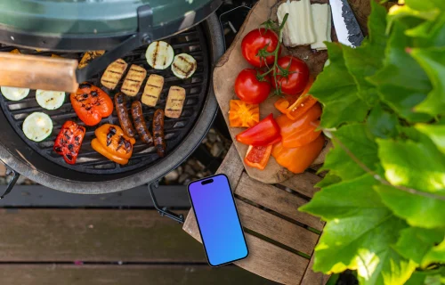 Grilled vegetables next to the iPhone mockup