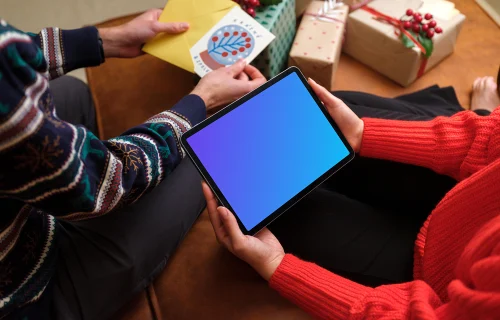 Holding iPad mockup and unpacking Christmas presents