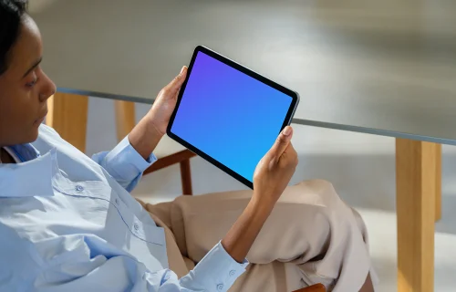 iPad Air mockup in a woman's hand at a modern office