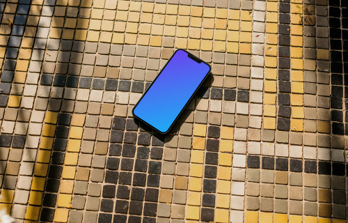 iPhone 13 mockup on a colorful garden paving
