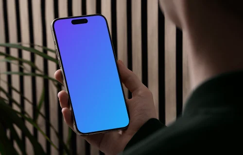 iPhone 15 Pro mockup in a male hand against a modern backdrop