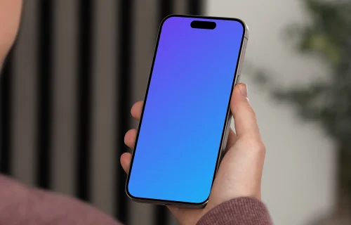 iPhone 15 Pro mockup in a man's hand against an indoor background