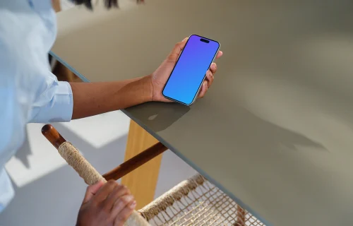 iPhone 15 Pro mockup in a woman's hand at a modern desk