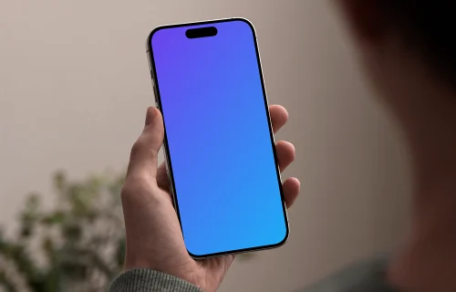 iPhone 15 Pro mockup in male hand against neutral background