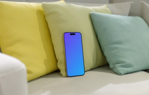 iPhone 15 Pro mockup on a cozy sofa with colorful cushions