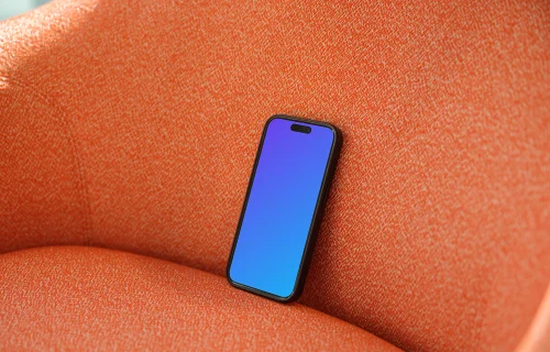 iPhone 15 Pro mockup on an orange fabric chair