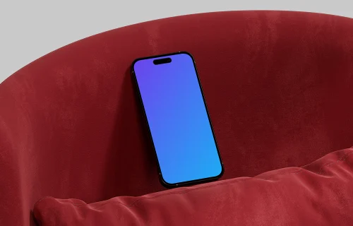 iPhone 16 mockup against a red cushion