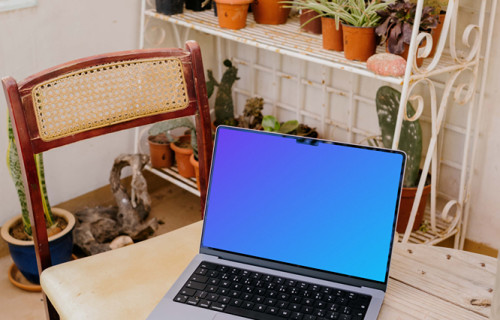 MacBook Pro mockup on a table next to a chair