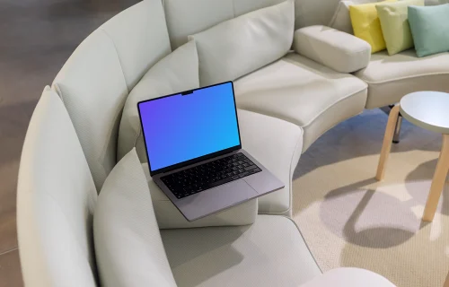 MacBook Pro mockup on modern sofa with colorful cushions