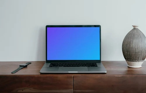 MacBook Pro mockup placed next to a vase and a knife