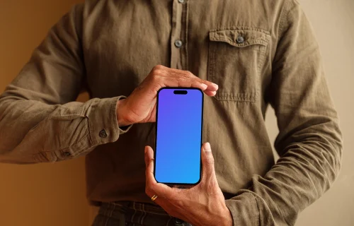 Grátis mockup de homem com camisa cáqui segurando o iPhone