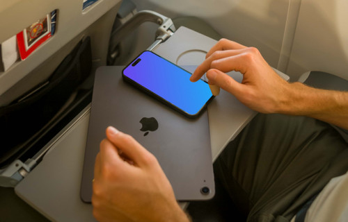 Un homme utilisant l'iPhone 14 Pro mockup assis dans un avion