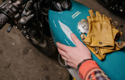 Man with a motorcycle holding an iPhone 13 Mockup