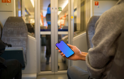 Passenger holding smartphone on the train mockup