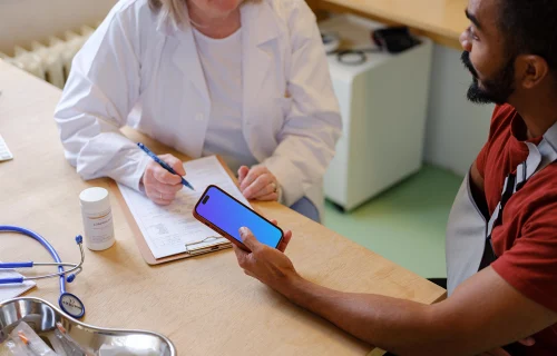 Patient holding an iPhone in doctor’s office