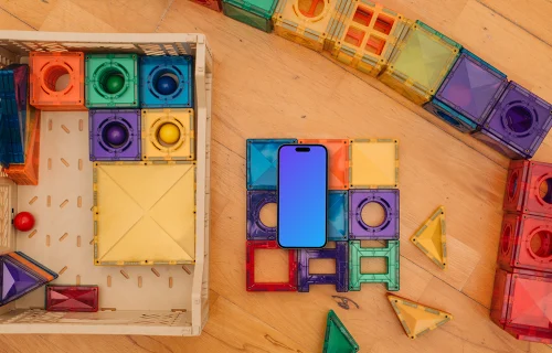 Smartphone mockup amidst colorful children's toys