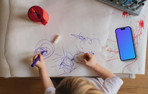 Smartphone mockup beside child's artwork