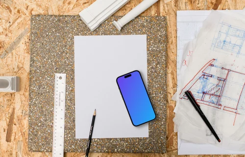Smartphone mockup on architect's table with tools